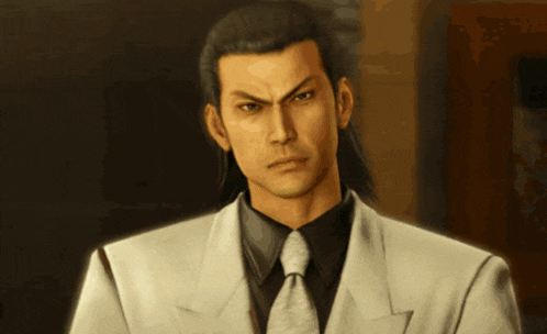a man in a white suit and tie looks serious