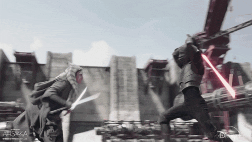 two men are fighting with lightsabers in front of a building that says disney plus