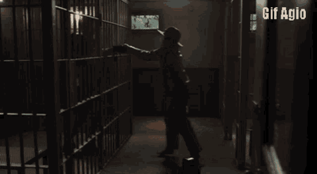 a gif of a man in a jail cell with the words gif agio below him