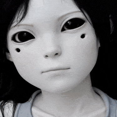 a close up of a doll with black eyes