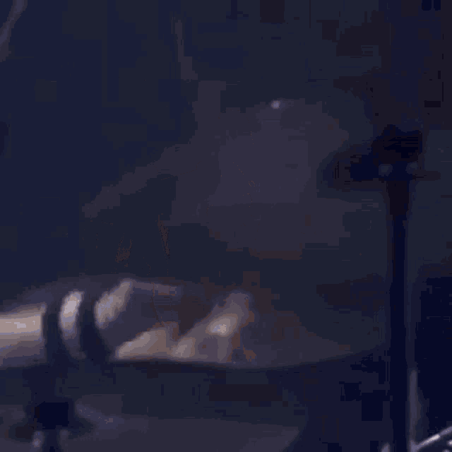 a man is playing a guitar on stage while wearing a scarf .