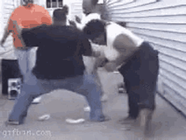 a group of people are dancing in front of a white house .