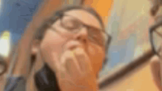 a close up of a woman wearing glasses and headphones .