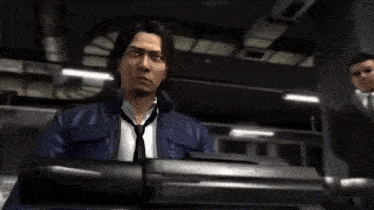 a man in a suit holds a gun in his hand