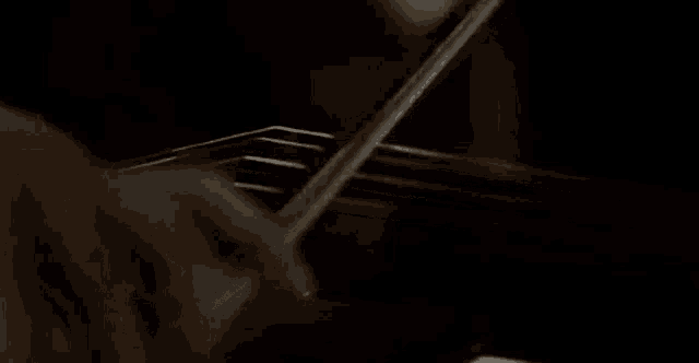 a close up of a person playing a violin in a dark room in a dark room .
