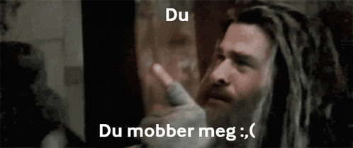 a man with dreadlocks is pointing at the camera with the words du mobber meg written above him