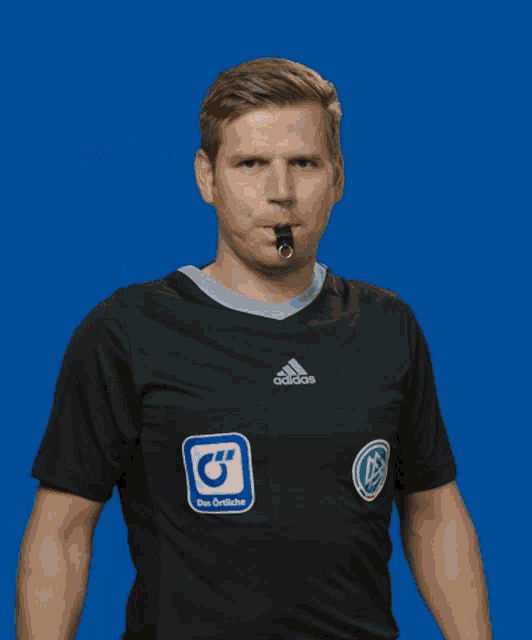 a man wearing a black adidas shirt holds up his finger