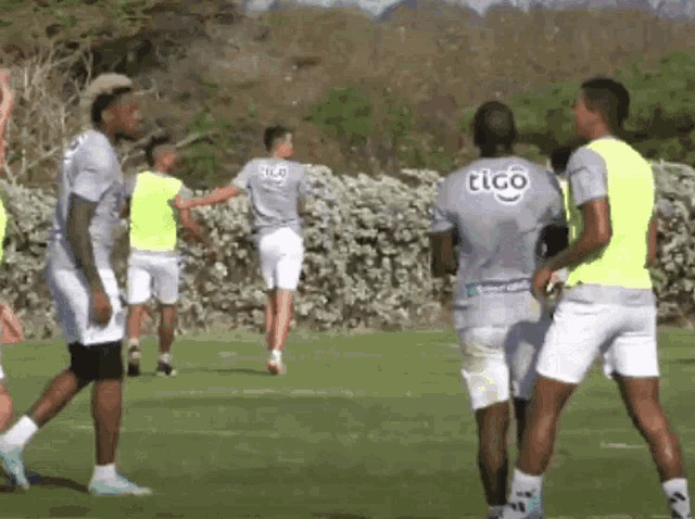 a group of soccer players are on a field and one of them is wearing a tico jersey