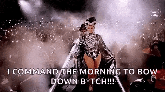a woman is walking on a stage in front of a crowd and says `` command the morning to bow down b * tch '' .