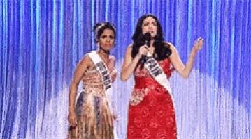 two women are standing next to each other with one wearing a sash that says canada