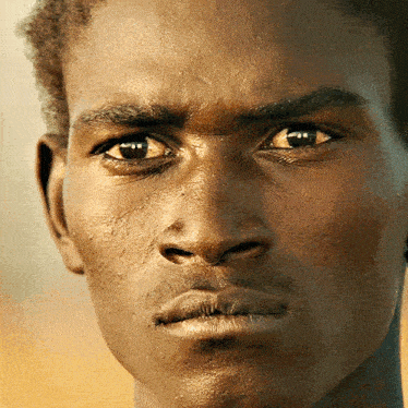a close up of a person 's face with a serious look on his face