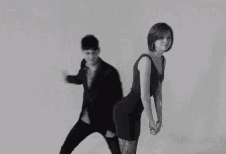 a man in a suit and a woman in a dress are dancing together .