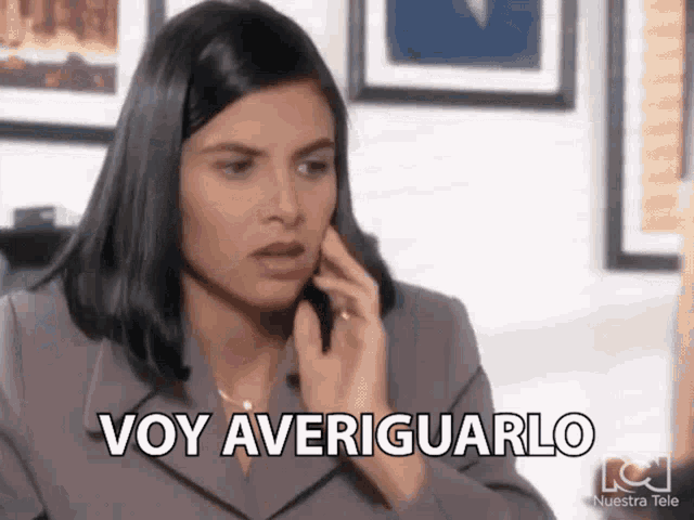 a woman is talking on a cell phone and making a funny face and saying voy averiguarlo .