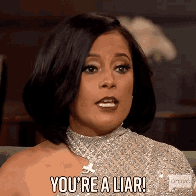 a woman in a gold dress is saying you 're a liar