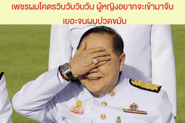 a man in a military uniform covering his eyes with his hand