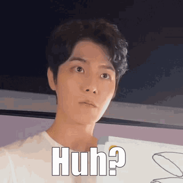 a man in a white shirt is making a funny face while holding a piece of paper with the words huh .