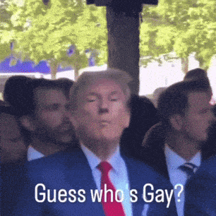 a man in a suit and tie says " guess who 's gay " in front of a crowd
