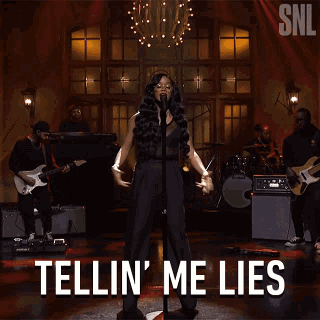 a woman singing into a microphone with the words tellin me lies above her