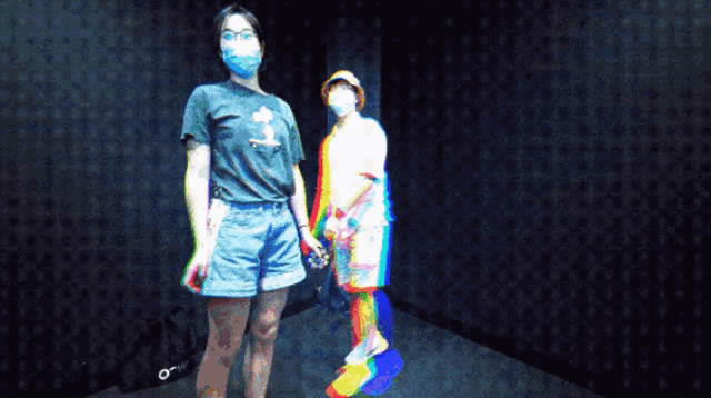 two people standing next to each other with one wearing a mask