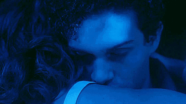a close up of a man 's face in a dark blue light