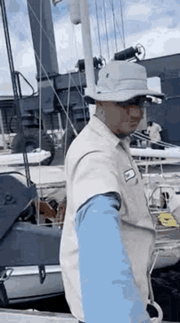 a man wearing a hat is standing on a boat .