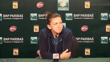 a woman sitting in front of a bnp paribas banner