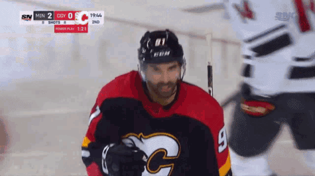 a hockey player in a red and black jersey with the number 9 on it