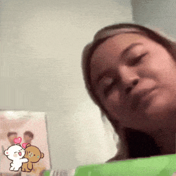 a woman is looking at a picture of a bear with a heart on it