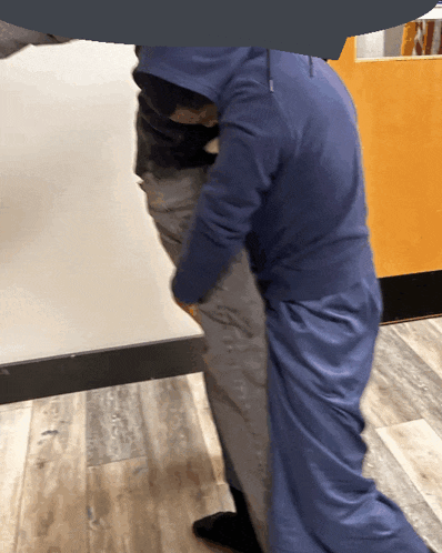 a person in a blue hoodie is holding another person