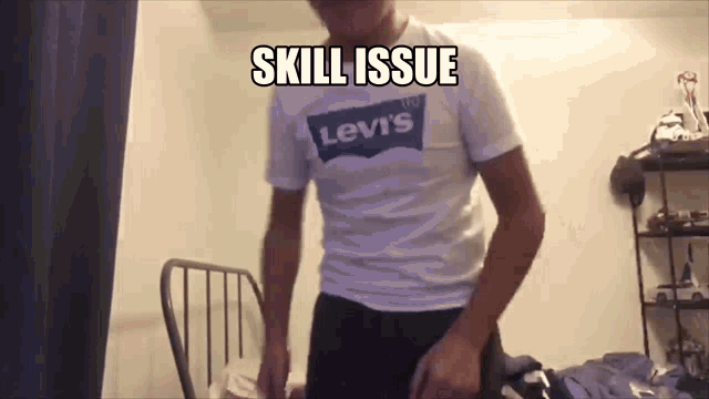 a man wearing a levi 's shirt is standing in front of a chair