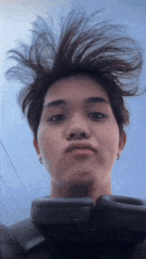 a young man with messy hair is wearing headphones .