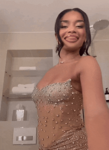a woman in a strapless dress with pearls on it is smiling