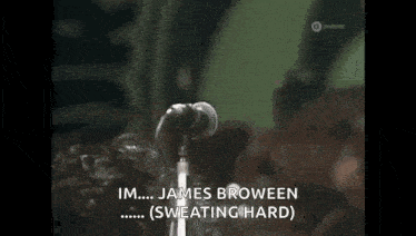 a man is singing into a microphone with his eyes closed .