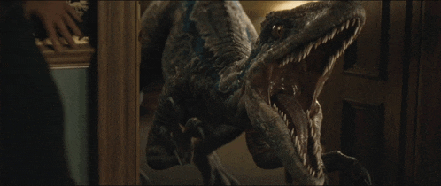 a close up of a dinosaur with its mouth open looking at the camera
