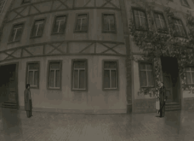 a black and white photo of two people standing in front of a building