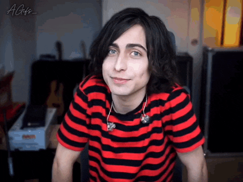 a young man wearing a red and black striped shirt with a gifs watermark