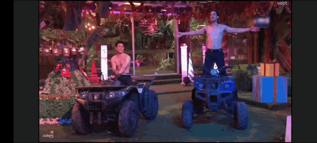 a man without a shirt is riding an atv next to another man without a shirt on .