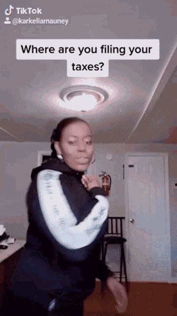 a woman is dancing in a room with the caption where are you filing your taxes ?