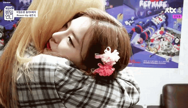 two girls hugging each other in front of a poster that says jtbc 4