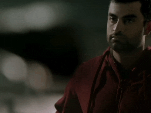 a man in a red hoodie looks at something