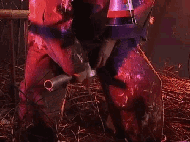 a person in a red suit is holding a hammer in a field .