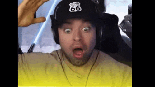 a man wearing headphones and a route 66 hat is making a funny face .