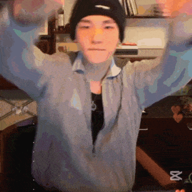 a person wearing a beanie and a jacket with the letter x on the bottom right