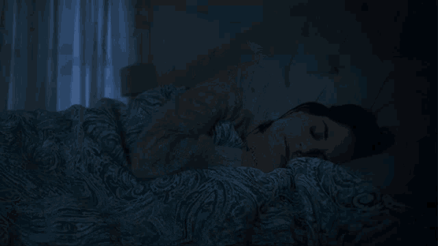a blurry picture of a woman laying on a bed