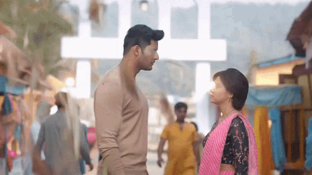 a man and a woman are standing next to each other and looking at each other