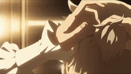 a close up of a person 's hand touching another person 's head