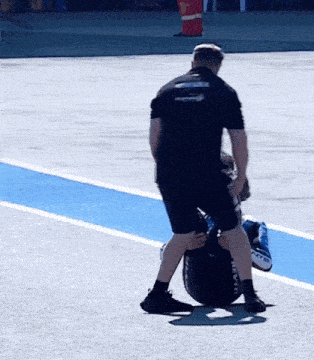 a man wearing a black shirt that says ' motorsports ' on it