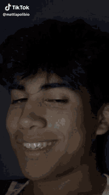 a close up of a young man 's face with a tik tok watermark