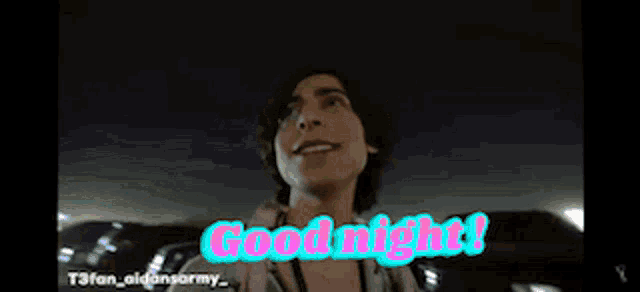 a man says good night in a parking lot at night