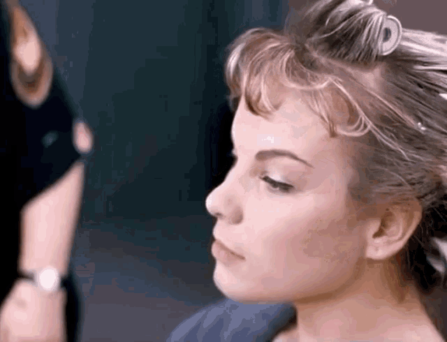 a woman with curlers in her hair is looking at something